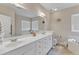 Bright bathroom features double vanity, tile flooring, and large mirror at 202 Reeder Branch Dr, Clayton, NC 27520