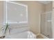 Bathroom with tiled corner bathtub and a glass-enclosed shower at 202 Reeder Branch Dr, Clayton, NC 27520
