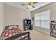 Well-lit bedroom features a ceiling fan, neutral carpet, and a desk area, perfect for studying or relaxing at 202 Reeder Branch Dr, Clayton, NC 27520