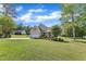 Wide shot of the home, revealing the spacious lawn, mature trees, and the overall neighborhood aesthetic at 202 Reeder Branch Dr, Clayton, NC 27520