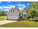 Charming single-Gathering home featuring a manicured lawn, two-car garage, and inviting front porch at 202 Reeder Branch Dr, Clayton, NC 27520