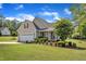Beautiful home with a two-car garage, landscaped garden, and a charming front porch with seating at 202 Reeder Branch Dr, Clayton, NC 27520