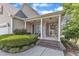 Inviting covered front porch with brick steps, seating area, and a decorative wreath on the front door at 202 Reeder Branch Dr, Clayton, NC 27520