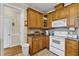 Bright kitchen featuring wooden cabinets, tiled backsplash, and modern white appliances at 202 Reeder Branch Dr, Clayton, NC 27520