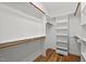 Spacious walk-in closet with custom built-in shelving and wood floors at 208 Willowbend Ln, Hillsborough, NC 27278