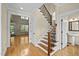 Open entryway featuring hardwood floors, staircase with iron spindles and a view of the living room at 208 Willowbend Ln, Hillsborough, NC 27278