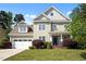 Inviting two-story home with a manicured lawn, attached garage, and charming front porch at 208 Willowbend Ln, Hillsborough, NC 27278