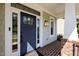 Inviting front porch with a brick floor, blue door, side lights, and white trim at 208 Willowbend Ln, Hillsborough, NC 27278