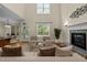 Bright living room with a soaring ceiling, fireplace, large window and hardwood floors at 208 Willowbend Ln, Hillsborough, NC 27278