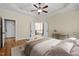 Relaxing main bedroom featuring a tray ceiling, ceiling fan, and ensuite bathroom access at 208 Willowbend Ln, Hillsborough, NC 27278