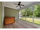 Screened-in porch with wood flooring, ceiling fan, and wooded backyard view at 208 Willowbend Ln, Hillsborough, NC 27278