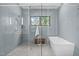 Spa-like bathroom with a freestanding tub, walk-in shower, elegant blue tile, and a towel rack at 2104 Manuel St, Raleigh, NC 27612