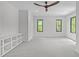 Spacious bonus room with carpeted floors, two windows, a ceiling fan, and built-in shelving at 2104 Manuel St, Raleigh, NC 27612