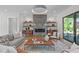 Inviting living room with a fireplace, floating shelves, modern lighting, and access to the patio at 2104 Manuel St, Raleigh, NC 27612
