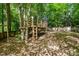 Backyard playhouse nestled among the trees, providing a fun and adventurous space at 215 Hopesworth Ct, Hillsborough, NC 27278