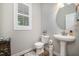 Clean powder room with a pedestal sink, neutral tones, and plantation shutters on the window at 215 Hopesworth Ct, Hillsborough, NC 27278