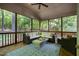 Inviting screened porch featuring comfortable wicker seating and views of the serene, wooded surroundings at 215 Hopesworth Ct, Hillsborough, NC 27278