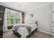 Cozy bedroom featuring a queen bed, large window, soft lighting, and neutral décor at 221 Obsidian Dr, Holly Springs, NC 27540