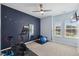 Bedroom featuring an exercise bike, ceiling fan, and blue accent wall for working out at 221 Obsidian Dr, Holly Springs, NC 27540