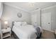 Comfortable bedroom with queen bed, soft bedding, a stylish light fixture, and access to two entry doors at 221 Obsidian Dr, Holly Springs, NC 27540