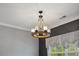 Contemporary chandelier in a bonus room with a window seat, gray accent wall, and neutral carpet at 221 Obsidian Dr, Holly Springs, NC 27540