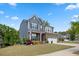 Exterior of a two-story home featuring a stone facade and a manicured lawn at 221 Obsidian Dr, Holly Springs, NC 27540