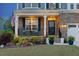Charming front porch with stone detail, rocking chairs, and manicured landscaping at 221 Obsidian Dr, Holly Springs, NC 27540