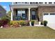 Charming front porch with rocking chairs, surrounded by flowers and greenery at 221 Obsidian Dr, Holly Springs, NC 27540