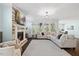 Cozy living room features a stone fireplace, large windows and comfortable seating at 221 Obsidian Dr, Holly Springs, NC 27540