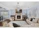 Open-concept living room featuring a stone fireplace and seamless transition to the dining area at 221 Obsidian Dr, Holly Springs, NC 27540