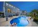 Backyard pool featuring sunbathing chairs and patio area with a two-story home at 221 Obsidian Dr, Holly Springs, NC 27540