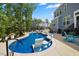 Sparkling pool area with modern lounge chairs, lush greenery, and elegant patio at 221 Obsidian Dr, Holly Springs, NC 27540
