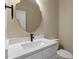 Elegant bathroom vanity featuring modern mirror and faucet, with a white marble countertop and backsplash and minimalist design at 2405 Pearces Rd, Zebulon, NC 27597