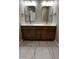 Bathroom featuring a double vanity with marble countertops, wood cabinets, and modern fixtures at 2405 Pearces Rd, Zebulon, NC 27597