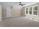 Spacious bedroom features a ceiling fan, carpeted floor, and bright natural light from the large windows at 2405 Pearces Rd, Zebulon, NC 27597