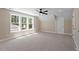 Spacious bedroom features a ceiling fan, carpeted floor, and bright natural light from the large windows at 2405 Pearces Rd, Zebulon, NC 27597