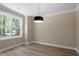 Bright bedroom with a large window, neutral walls, and a modern light fixture, offering a serene and inviting space at 2405 Pearces Rd, Zebulon, NC 27597