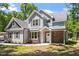 Charming two-story home featuring a stone accent wall and gray siding, complemented by well-manicured landscaping and a cozy entrance at 2405 Pearces Rd, Zebulon, NC 27597