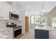 Stylish kitchen featuring white cabinets, stainless steel appliances, quartz countertops, and an island with pendant lighting at 2405 Pearces Rd, Zebulon, NC 27597