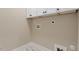 Bright laundry room with white cabinets and marble style tile flooring at 2405 Pearces Rd, Zebulon, NC 27597