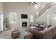 Cozy living room with a fireplace, large windows, and elegant staircase at 2405 Pearces Rd, Zebulon, NC 27597