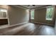 Bright main bedroom with hardwood floors, tray ceilings, two large windows, and an en-suite bathroom at 2405 Pearces Rd, Zebulon, NC 27597