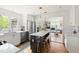 The modern kitchen features stainless steel appliances, white cabinets, an island with bar seating and a view to living room at 2481 Foxwood Dr, Chapel Hill, NC 27514