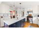 Island kitchen featuring barstool seating, stainless appliances, and white cabinets with warm wood flooring throughout at 2481 Foxwood Dr, Chapel Hill, NC 27514