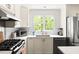 The bright kitchen offers stainless steel appliances, white cabinets, lots of natural light, and sleek counter tops at 2481 Foxwood Dr, Chapel Hill, NC 27514