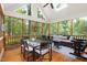 Comfortable screened in porch with wooden floors, seating, and wooded views, providing a serene outdoor living space at 2481 Foxwood Dr, Chapel Hill, NC 27514