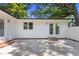 Backyard view of the home, featuring an outdoor patio, white siding, and a lush green yard with mature trees at 2505 Catalina Ct, Raleigh, NC 27607
