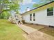 Backyard view, showing the back of the house, a concrete patio, and landscaping with blooming plants at 2505 Catalina Ct, Raleigh, NC 27607