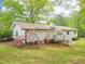 The home's exterior features white siding, a new roof, and beautifully landscaped grounds with vibrant, blooming plants at 2505 Catalina Ct, Raleigh, NC 27607