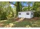 White storage shed surrounded by lush greenery, offering practical storage space and blending seamlessly with the natural landscape at 2505 Catalina Ct, Raleigh, NC 27607